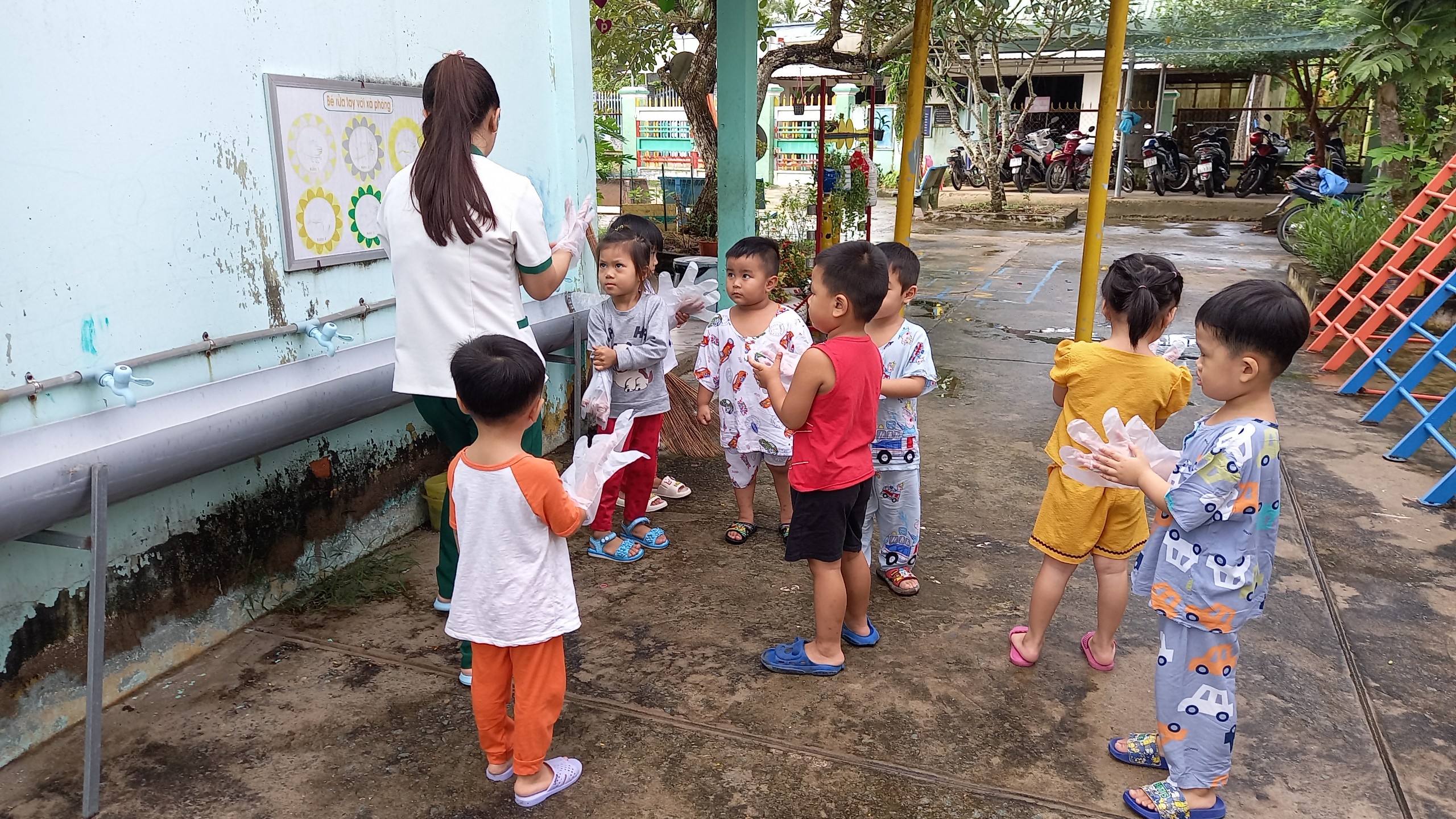 Trẻ lớp Mầm thu gom rác trên sân trường góp phần bảo vệ môi trường